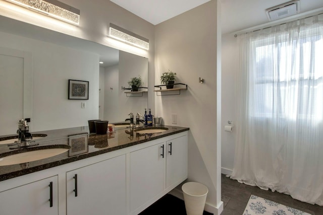 full bath with double vanity, visible vents, tile patterned floors, and a sink