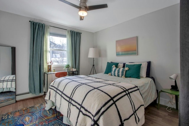 bedroom with a baseboard radiator, baseboards, a ceiling fan, and wood finished floors