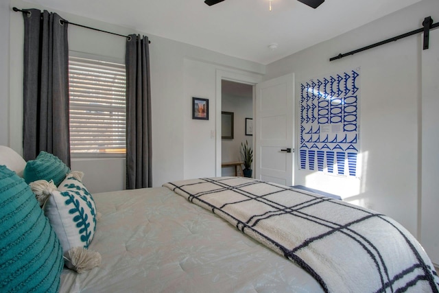 bedroom featuring a barn door and a ceiling fan