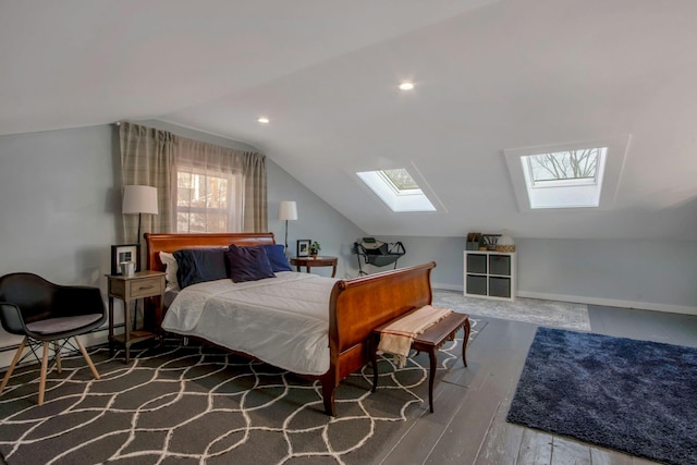 bedroom with vaulted ceiling with skylight, a baseboard radiator, baseboards, and wood finished floors