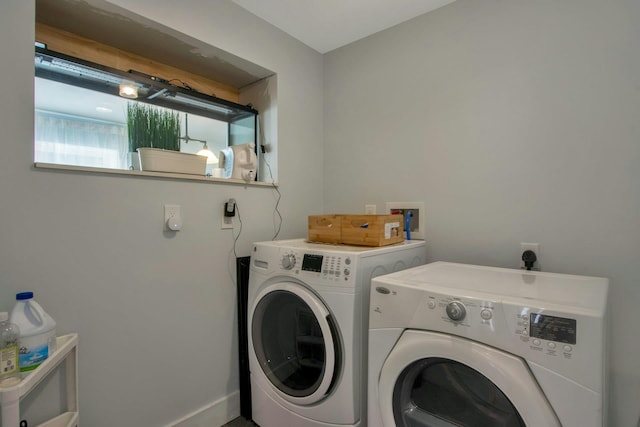 washroom with baseboards, laundry area, and washer and clothes dryer