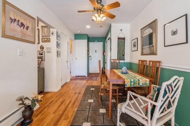 dining area with recessed lighting, a baseboard heating unit, wood finished floors, a ceiling fan, and baseboards