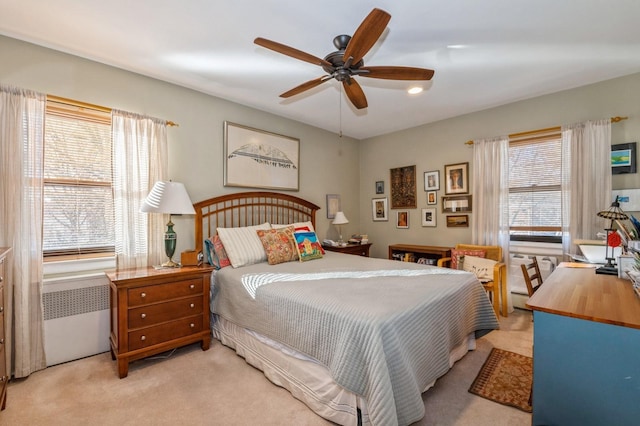 bedroom featuring light carpet, a baseboard heating unit, radiator heating unit, and a ceiling fan