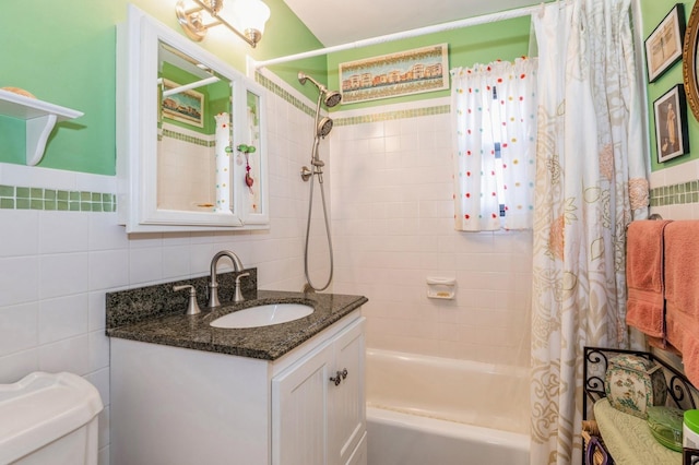 bathroom featuring toilet, tile walls, shower / bath combination with curtain, and vanity