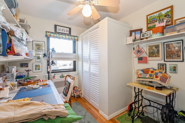 interior space featuring a ceiling fan, baseboards, and wood finished floors