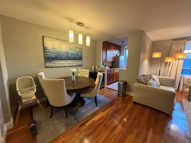 dining space with dark wood finished floors and baseboards