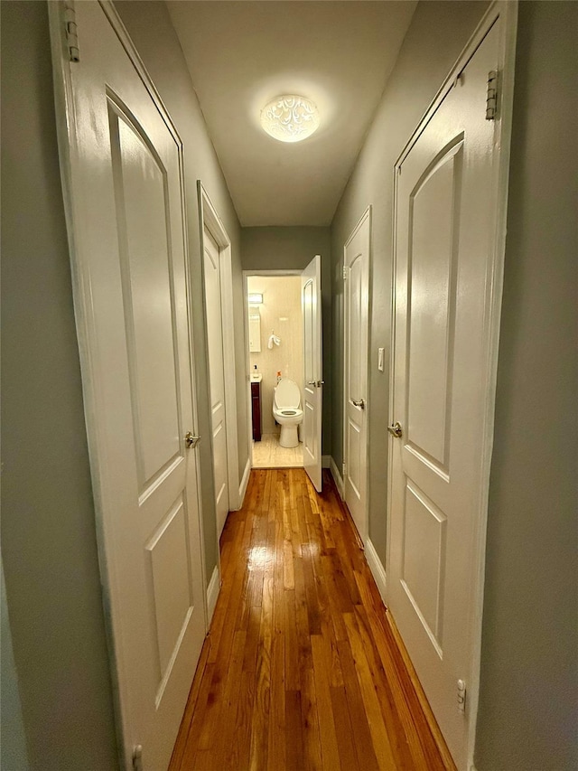 hall featuring wood finished floors and baseboards