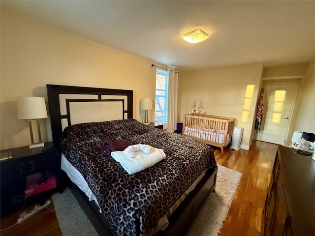 bedroom featuring baseboards and wood finished floors