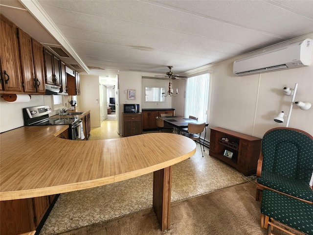 kitchen featuring a peninsula, stainless steel electric stove, a wall mounted AC, a sink, and exhaust hood