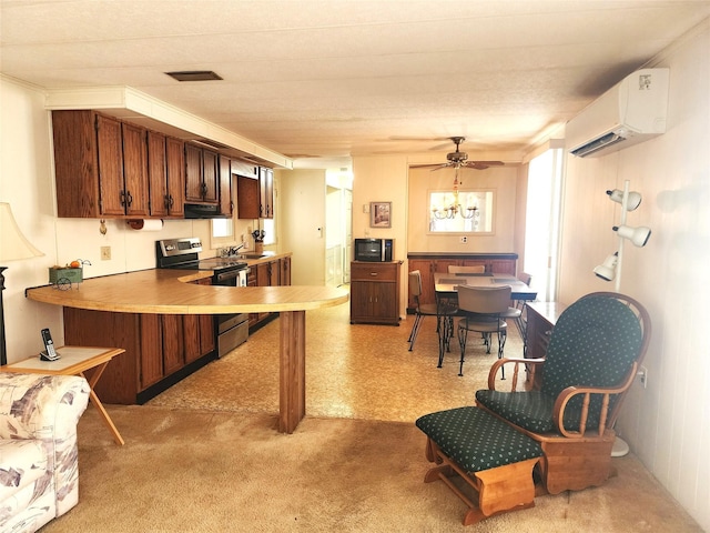 kitchen featuring visible vents, electric range, an AC wall unit, a sink, and a peninsula