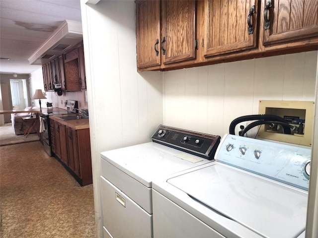 clothes washing area with separate washer and dryer and a sink