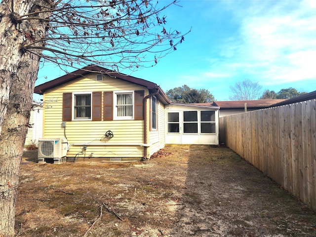 view of side of property featuring ac unit, a sunroom, fence, and crawl space