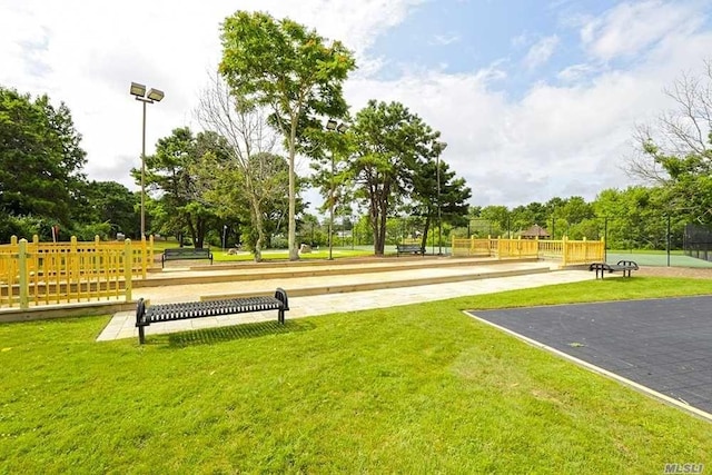 view of property's community featuring fence and a lawn