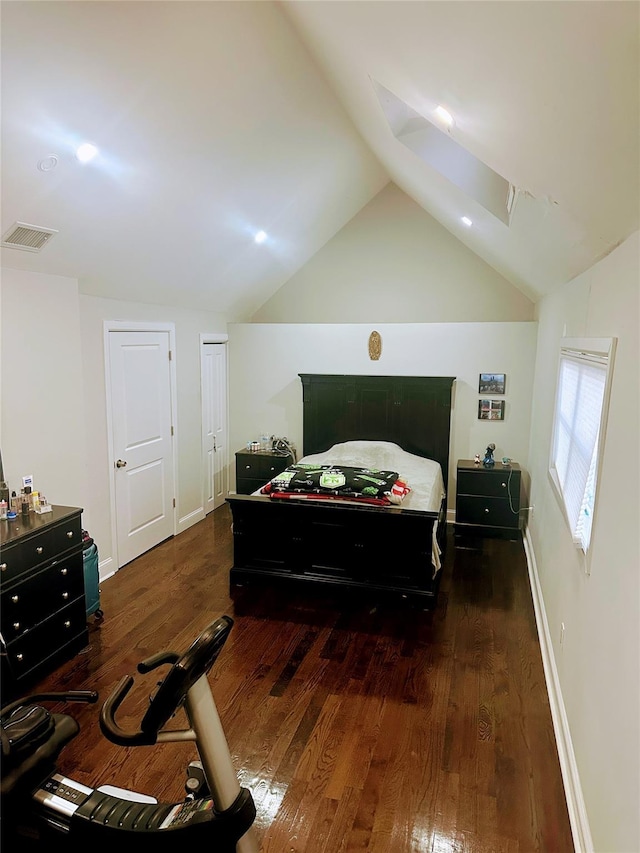 bedroom with lofted ceiling, baseboards, visible vents, and wood finished floors