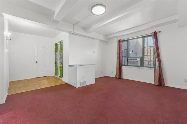 carpeted spare room featuring cooling unit, beam ceiling, and baseboards