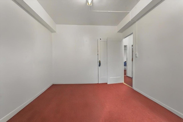 spare room with baseboards and carpet flooring