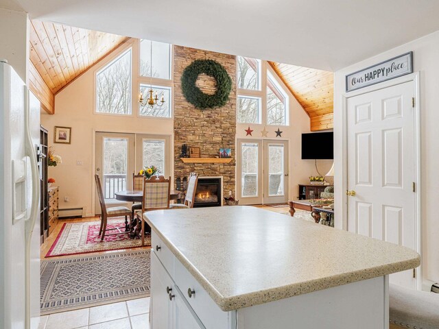 kitchen featuring french doors, baseboard heating, wood ceiling, white cabinetry, and white fridge with ice dispenser