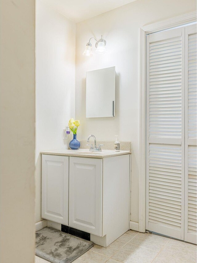 bathroom with tile patterned floors, a closet, and vanity