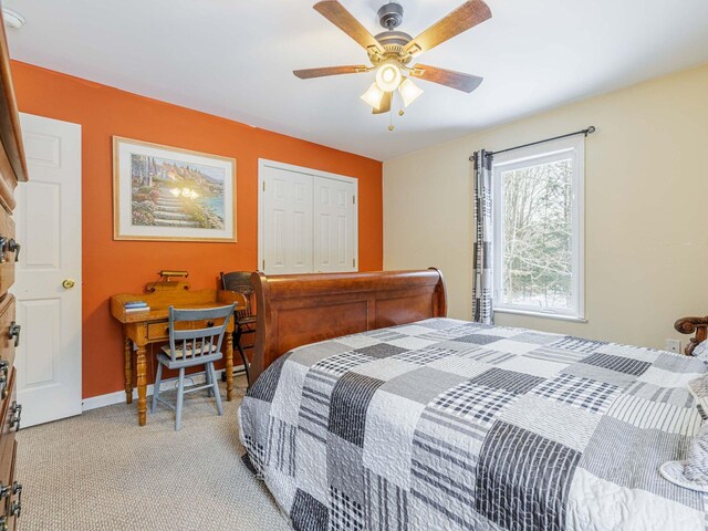 bedroom featuring ceiling fan, a closet, baseboards, and light colored carpet