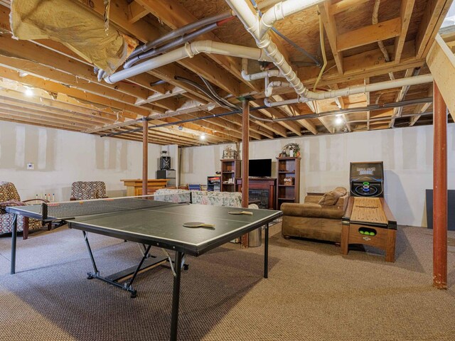 game room with a fireplace and carpet flooring