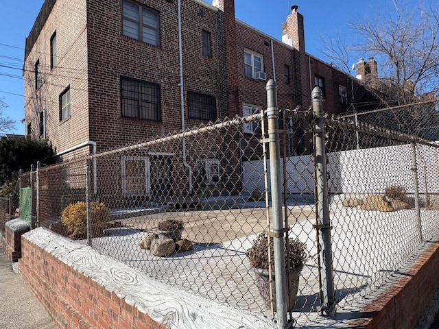 view of side of property with brick siding and fence