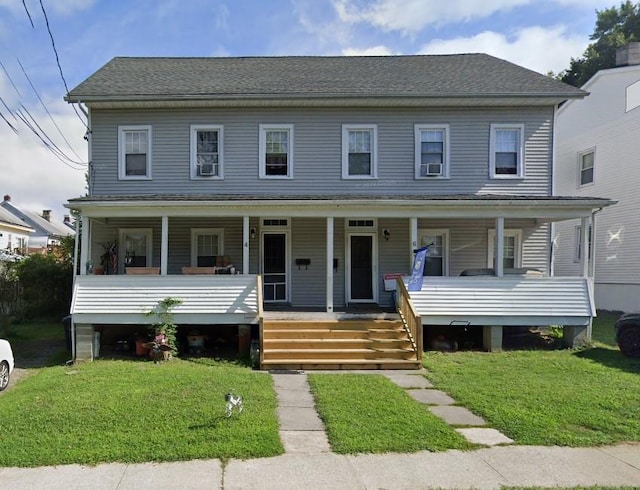 view of front facade featuring covered porch, a front lawn, and roof with shingles