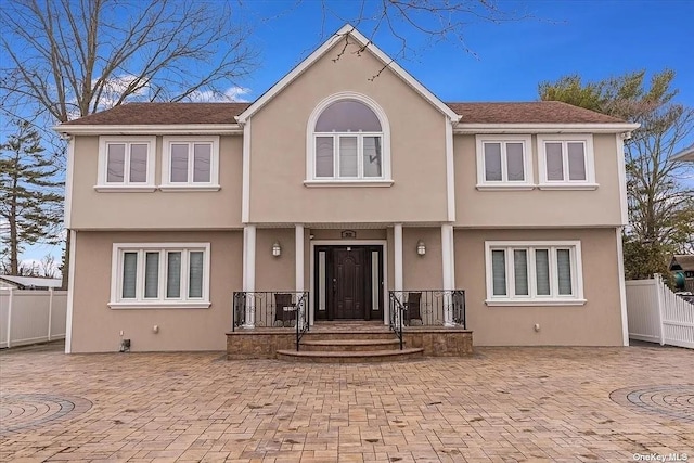 view of front of house featuring fence and stucco siding