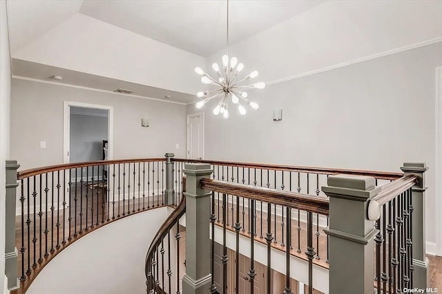 corridor with visible vents, a chandelier, crown molding, and an upstairs landing