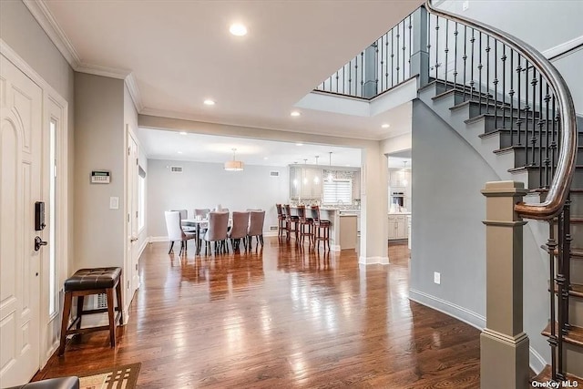 foyer featuring stairway, ornamental molding, and wood finished floors