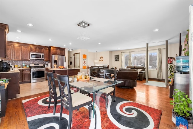 dining space featuring light wood-style flooring and recessed lighting