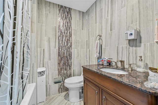 bathroom featuring toilet, tile walls, and vanity