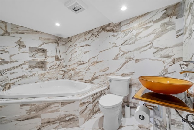 full bathroom featuring visible vents, toilet, stone wall, tiled tub, and a sink