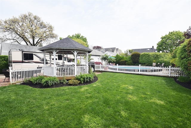 view of yard with fence, a fenced in pool, and a gazebo