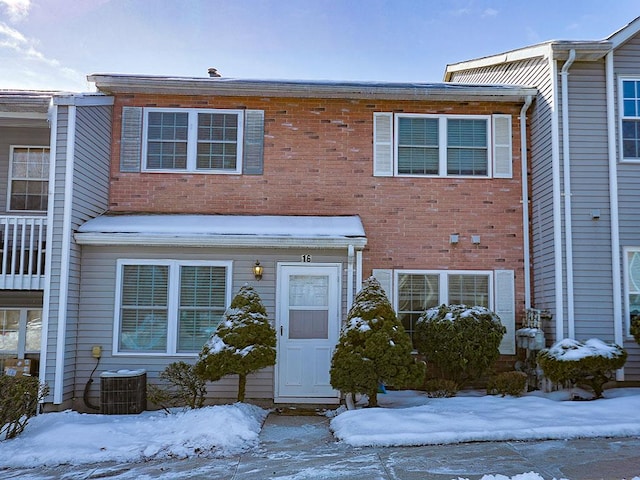 townhome / multi-family property featuring central AC unit and brick siding