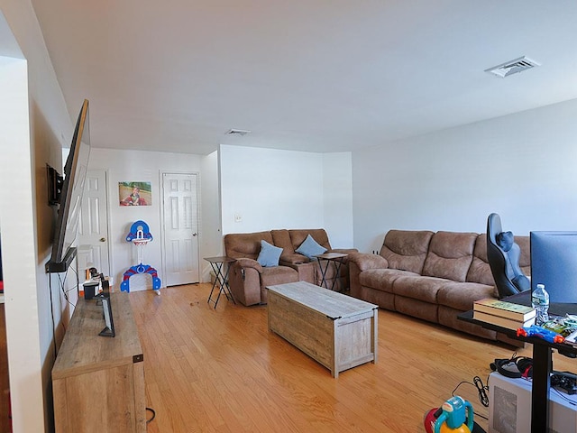 living room featuring light wood-style flooring and visible vents