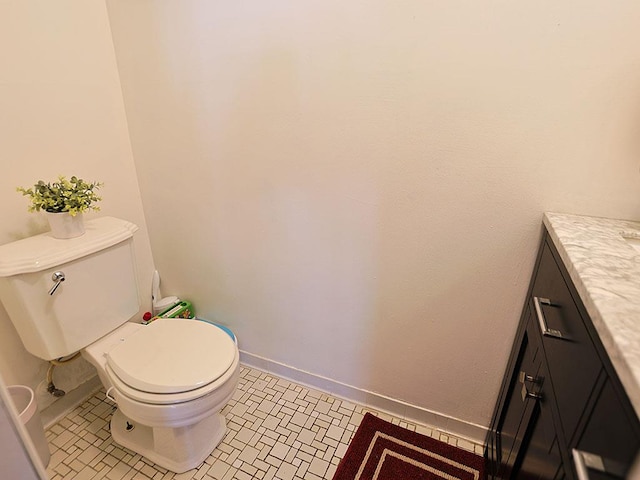 bathroom featuring tile patterned flooring, baseboards, vanity, and toilet