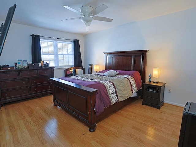 bedroom featuring light wood-type flooring, baseboards, and a ceiling fan