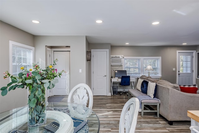 interior space with a wall unit AC, wood finished floors, and recessed lighting