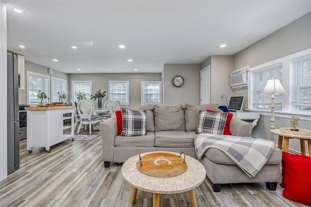 living area with beverage cooler, an AC wall unit, recessed lighting, and light wood-style floors