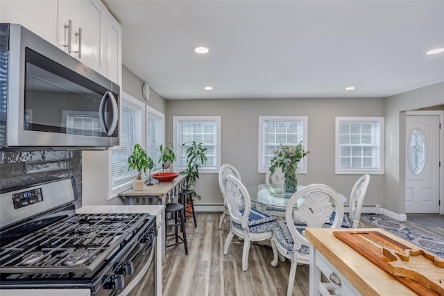 kitchen with stainless steel appliances, recessed lighting, white cabinets, and light wood finished floors