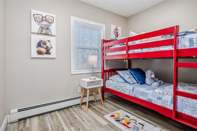 bedroom featuring baseboards, baseboard heating, and wood finished floors