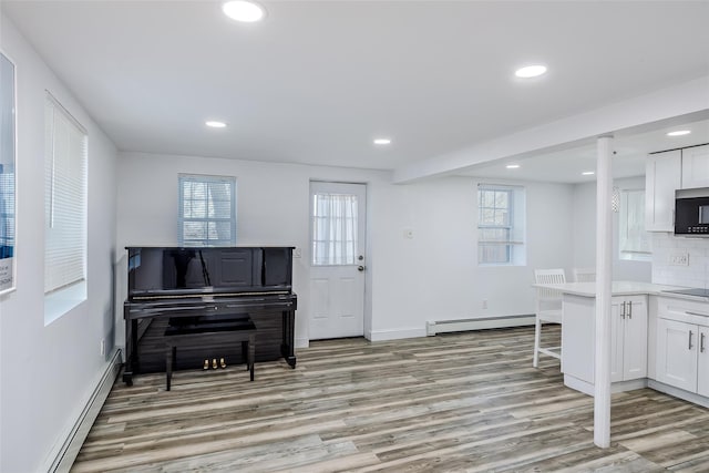 foyer entrance featuring a baseboard heating unit, recessed lighting, and light wood-style flooring