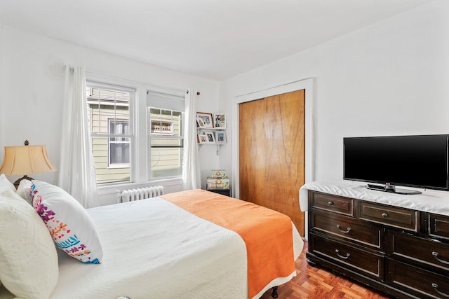 bedroom with radiator heating unit and a closet