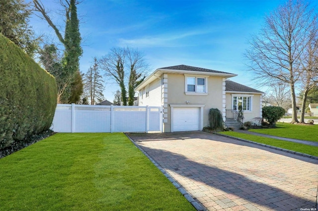 view of side of home with a garage, fence, a yard, decorative driveway, and stucco siding