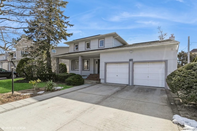 traditional-style house featuring driveway, an attached garage, and stucco siding