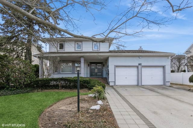 view of front of home featuring an attached garage, fence, concrete driveway, stucco siding, and a front yard