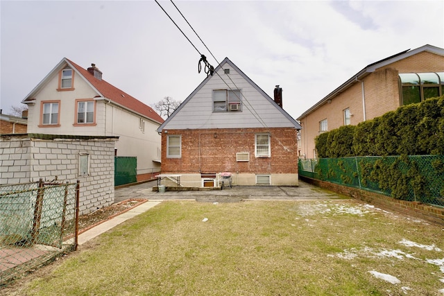 back of property with fence, a lawn, and brick siding