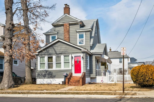 view of front of home featuring a chimney and fence