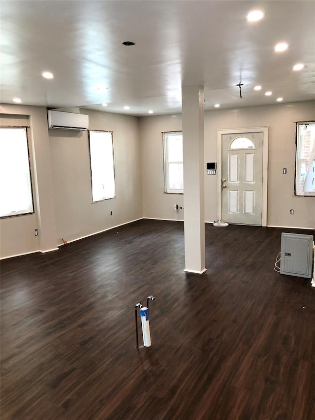 interior space with an AC wall unit, dark wood-style flooring, and recessed lighting