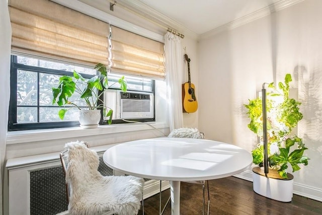 dining room featuring dark wood-type flooring, a healthy amount of sunlight, crown molding, and baseboards